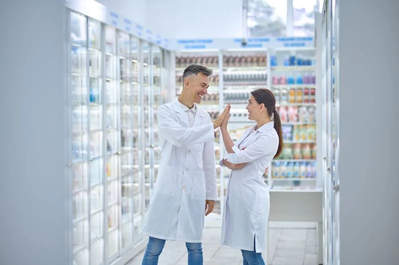 Dos Personas Batas Laboratorio Sintiendose Bien Sonriendo